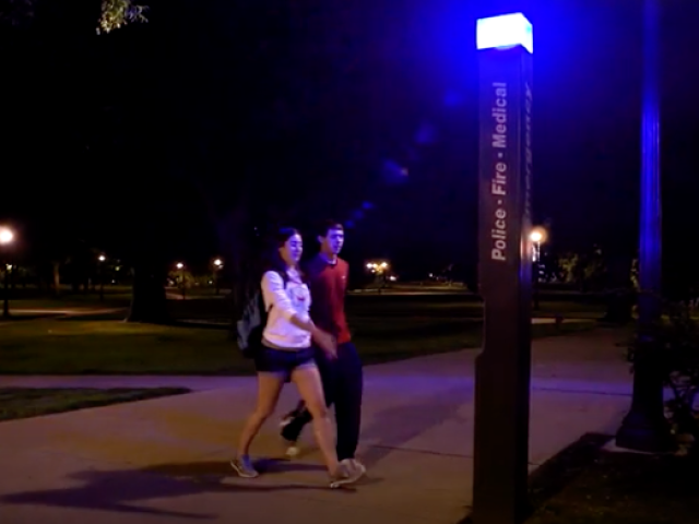 Students walking toward blue emergency light